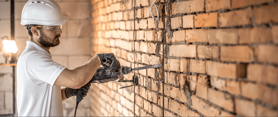 Altbausanierung – Handwerker beim Wanddurchbruch