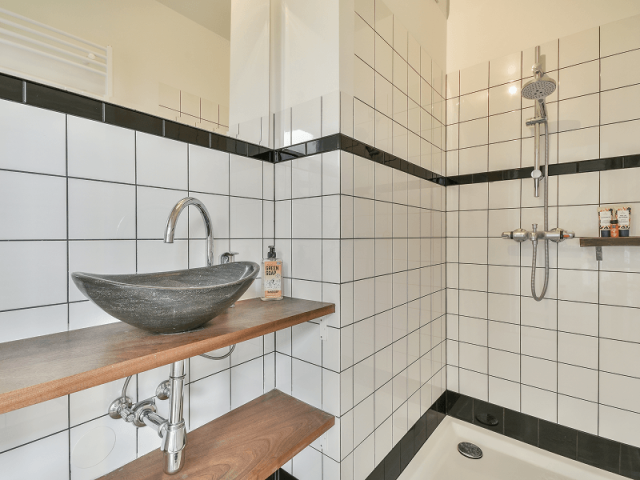 Badezimmer – gefliestes Bad mit Dusche und Waschtisch